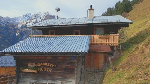 Una cabaña de madera con balcón en la montaña. en Grasreithütte, en Schied