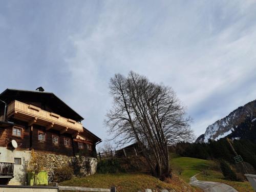 un edificio en una colina con un árbol al lado en Grasreithütte, en Schied