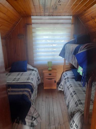 two twin beds in a room with a window at Casa completa en Horcón para 8 personas in Puchuncaví