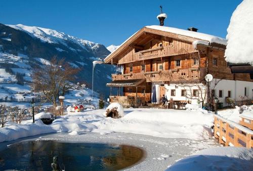 a log cabin in the snow with a pond at Bergchalet Klausner Edelweiß in Ramsberg