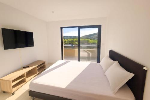 ein Schlafzimmer mit einem großen Bett und einem Fernseher in der Unterkunft Villa di Favona 4 chambres piscine privée in Conca