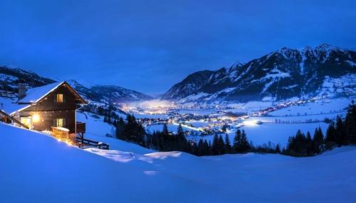a mountain cabin in the snow at night at Koflerhäusl in Aigen