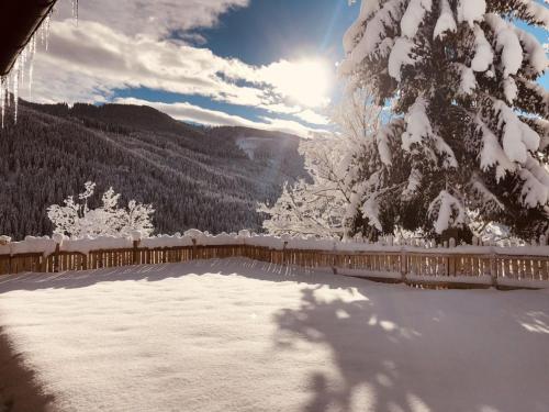 a snow covered yard with the sun in the background at Faschinghütte in Mühlbach am Hochkönig