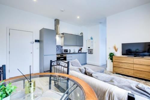 a living room with a couch and a glass table at Extra Large Modern Studio Flat In Kent in Maidstone
