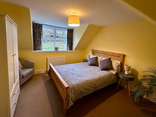 a bedroom with a large bed and a window at Cosy Cottage on the Whisky Trail in Haugh of Glass