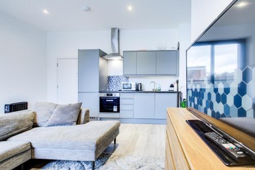 a living room with a couch and a kitchen at Extra Large Modern Studio Flat In Kent in Maidstone