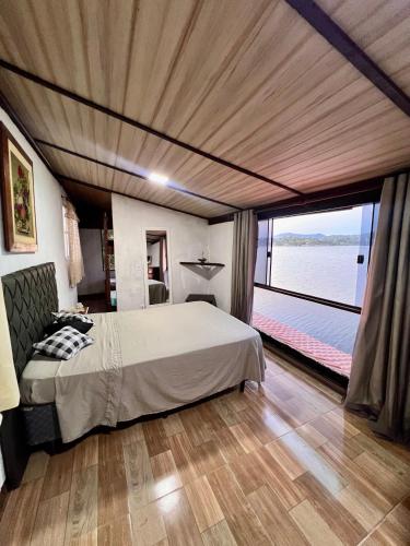 a bedroom with a large bed and a large window at Casa Lagoa da Diva in Maricá