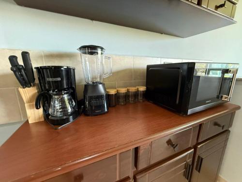 a kitchen counter with a blender and a microwave at Casa en residencial Metrópoli San Gabriel, Nejapa San Salvador in Nejapa