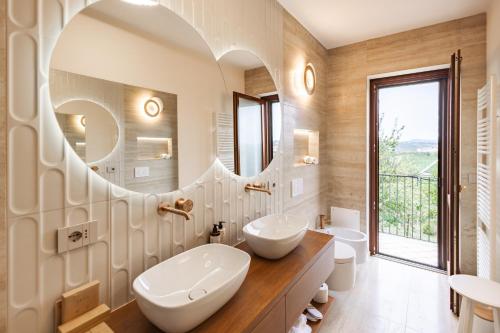 um banheiro com duas pias e um espelho grande em Casa Nizza D'Oro em Castelnuovo