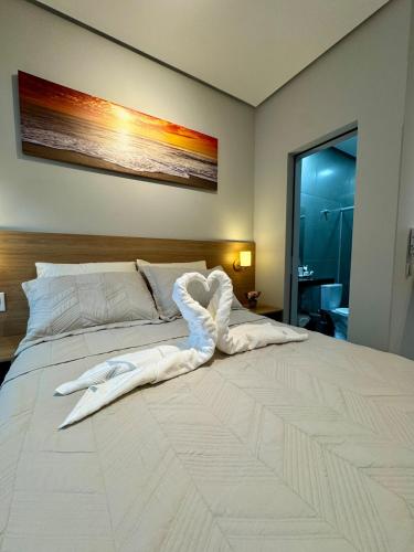 1 cama blanca grande en una habitación en Studio aconchegante com garagem privativa e varanda, en Montes Claros