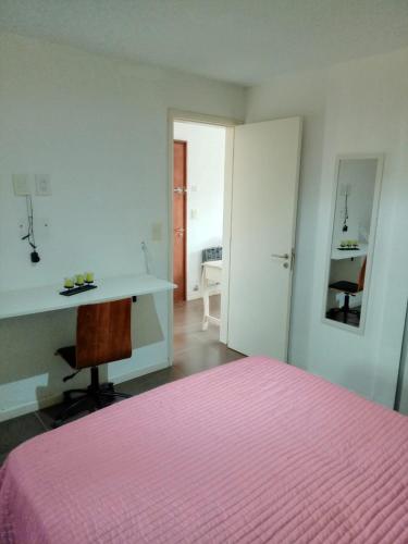 - une chambre avec un lit rose et un bureau dans l'établissement Departamento en Edificio La Argentina, à Ostende