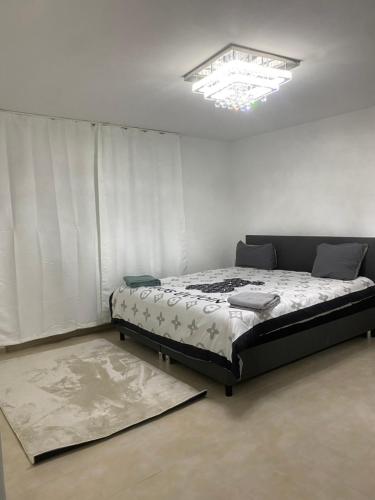 a bedroom with a bed in a room with a chandelier at 3 zimmer Apartment in Lörrach