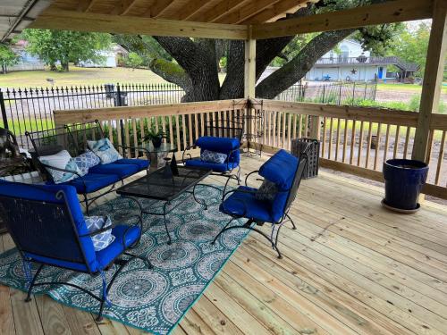 a patio with blue chairs and a table on a wooden deck at Lakefront Getaway in Lone Oak