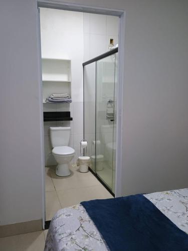 a bathroom with a toilet and a glass shower at Pousada Zero Três - 03 in Chapada dos Guimarães