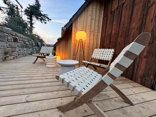 a wooden deck with two chairs and a lamp at Neu Daserbhaus in Großschönau