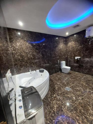 a bathroom with a toilet and a sink and a blue light at فندق دريم هاف in Jazan