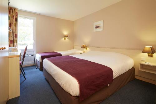 ein Hotelzimmer mit 2 Betten und einem Fenster in der Unterkunft Hôtel Kyriad Vernon / Saint Marcel in Saint-Marcel