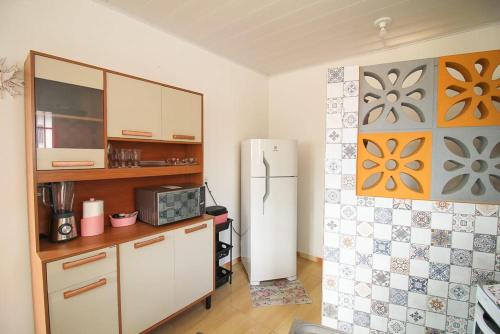 a kitchen with a refrigerator and a counter in it at Casa Jade Patacho in Pôrto de Pedras