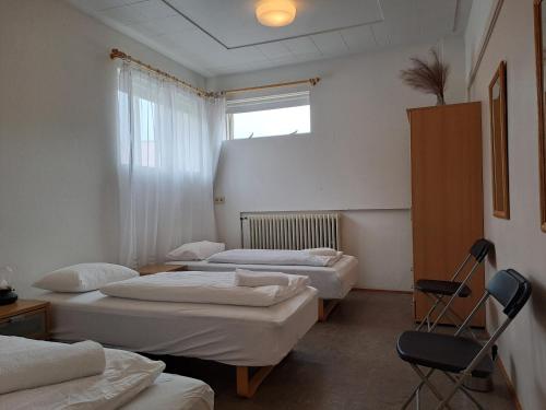 a room with three beds and a window at Studlagil INN Hostel in Skjöldólfsstaðir
