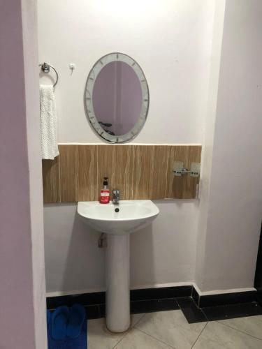 a bathroom with a white sink and a mirror at Del's Homes -Ruiru in Ruiru