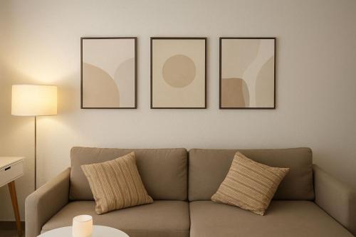 a living room with a couch and four pictures on the wall at SH Apartments in Hannover
