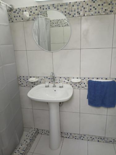 a white bathroom with a sink and a mirror at Cielo in Tafí del Valle