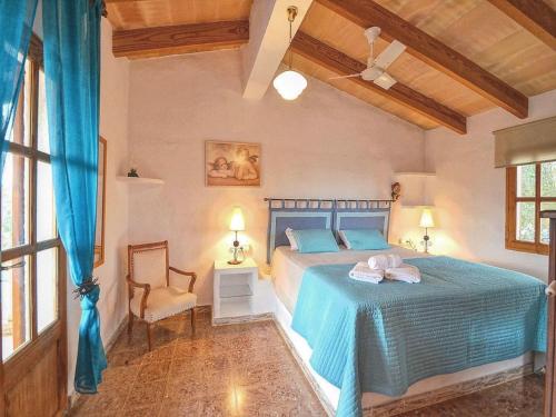 Un dormitorio con una cama azul y una silla. en Holiday Home in LLevant with private pool, en Maria de la Salut