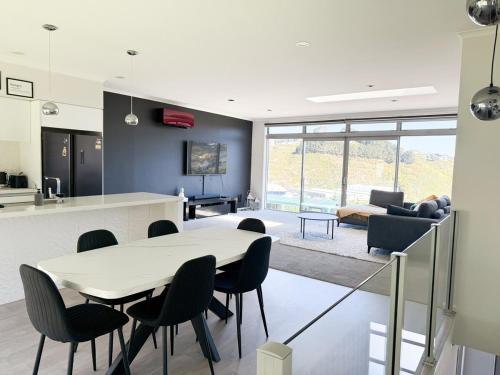 una cucina e un soggiorno con tavolo e sedie di Cosy Luxe --Modern 3 bedroom home in Johnsonville a Wellington