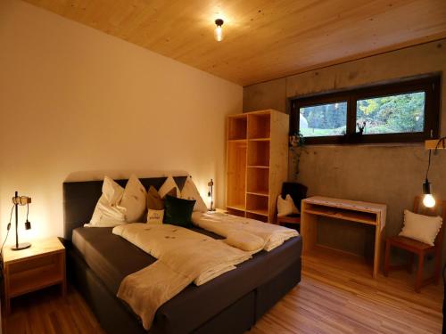 a bedroom with a large bed in a room with a window at Dog-friendly holiday apartment in Bregenzerwald in Sibratsgfäll