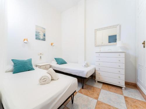 two twin beds in a room with a dresser at Seaside Escape in Benalmádena in Benalmadena Costa