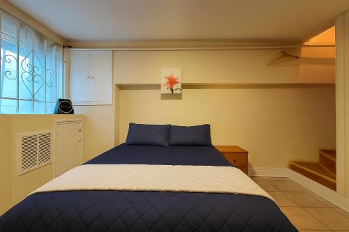 a bedroom with a blue bed and a window at Near Stadiums and Downtown in Peaceful Neighborhood in Baltimore