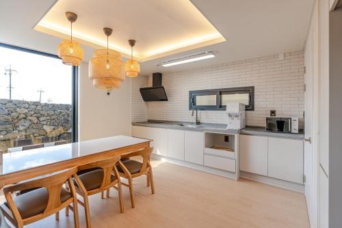 a kitchen with a table and chairs and a counter at In Aewol Forest 201 in Jeju