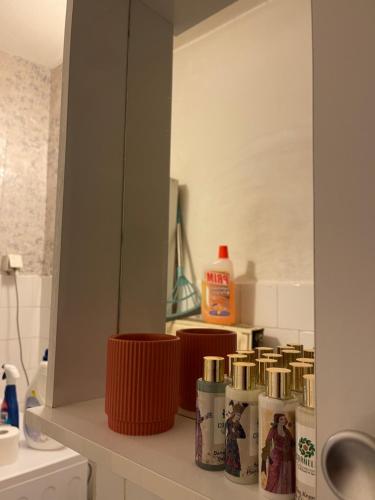 a bathroom counter with a mirror and toothbrushes at Prishtina Center Apartment in Pristina
