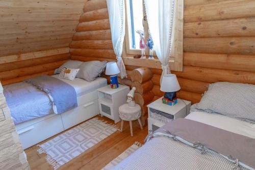 twee bedden in een kamer met houten wanden bij Holiday house with a parking space Belo Selo, Gorski kotar - 24979 in Donja Slavica