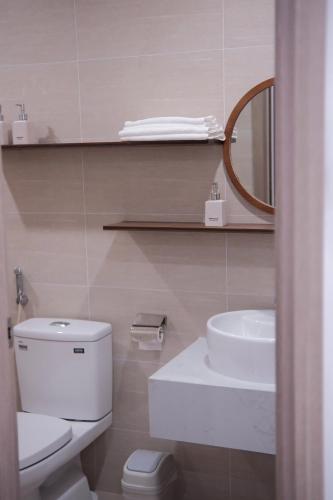 a bathroom with a toilet and a sink and a mirror at Winna Homestay - Nera Garden Huế in Thôn Văn Dương