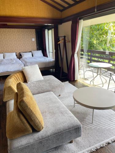 a living room with a couch and a bed and tables at Kori Terrace N in Kouri