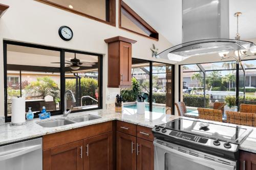 a kitchen with a sink and a stove top oven at Pirates Cove Marco Island, saltwater pool, bikes, water sports, paddle boards included! in Marco Island