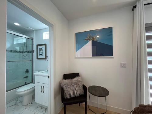 een badkamer met een toilet, een stoel en een tafel bij Minimalist Modern 3Bed 3Bath House near the Rose Bowl in Pasadena in Pasadena