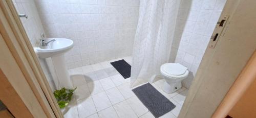 a bathroom with a toilet and a sink at Casa Lara - Carmelitas Asunción in Asuncion