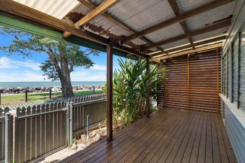 eine Holzterrasse mit Pergola an einem Haus in der Unterkunft Beach Shack in Machans Beach