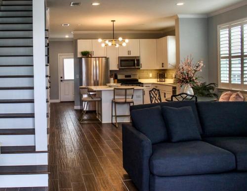 a living room with a couch and a kitchen at The Pensacola Retreat-Spacious, pet-friendly home in Pensacola