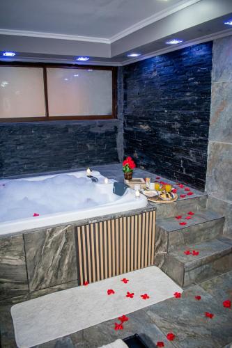 a bathroom with a large tub with red flowers on the floor at Spa la casona de pirque in Pirque