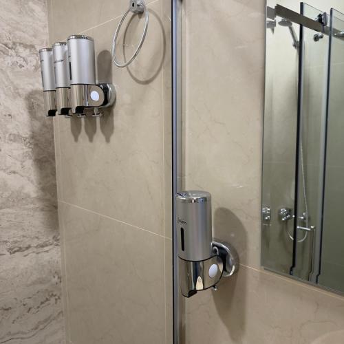 a shower with a glass door and a mirror at Espacio Uno B in Belén de Escobar