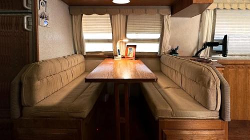 a table in the back of a trailer with a couch at Retro Star-Wagon, Ocean View at Studios in Oceanside
