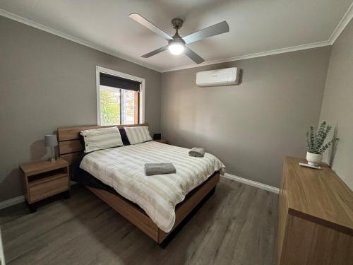 ein Schlafzimmer mit einem Bett mit Deckenventilator in der Unterkunft Park, Outdoor Gym, Sports Oval, 3 Queen Room House in Broken Hill