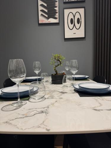 a table with wine glasses and plates on it at Luxury flat with FREE parking & easy tube access! in London