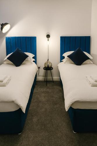 two beds sitting next to each other in a room at Luxury flat with FREE parking & easy tube access! in London