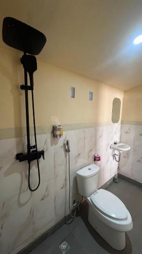 a bathroom with a toilet and a camera on the wall at Pin senaru accomodation in Senaru