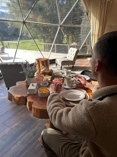 um homem sentado à mesa com comida em Alma Andina em Puelo