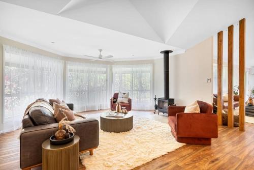 a living room with two couches and a fireplace at The Hideaway in Tintenbar